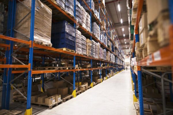 interior-large-distribution-warehouse-with-shelves-stacked-with-palettes-goods-ready-market 1